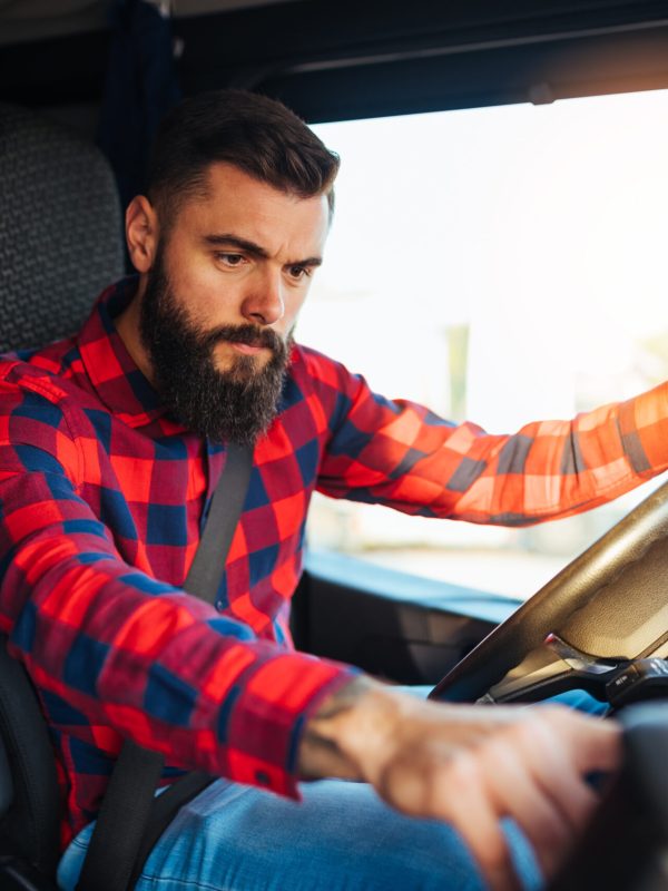 Young handsome bearded man driving his truck.