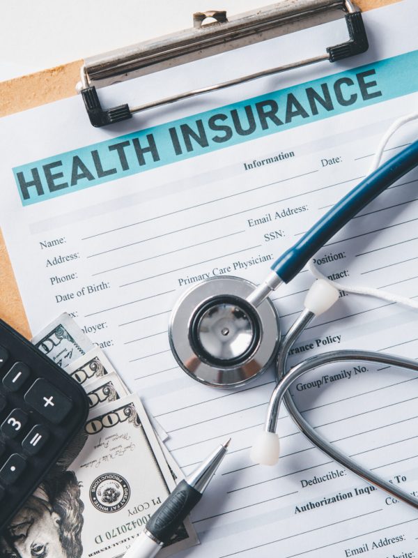 Stethoscope and calculator placed on health insurance documents, Individual medical health insurance. Concept life planning